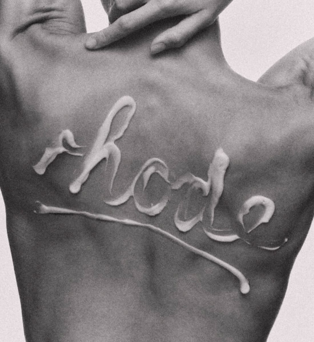 rhode written on model's back with barrier butter