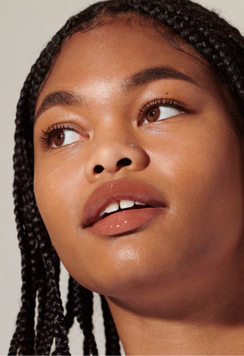 model with glossy lips, wearing toast lip tint