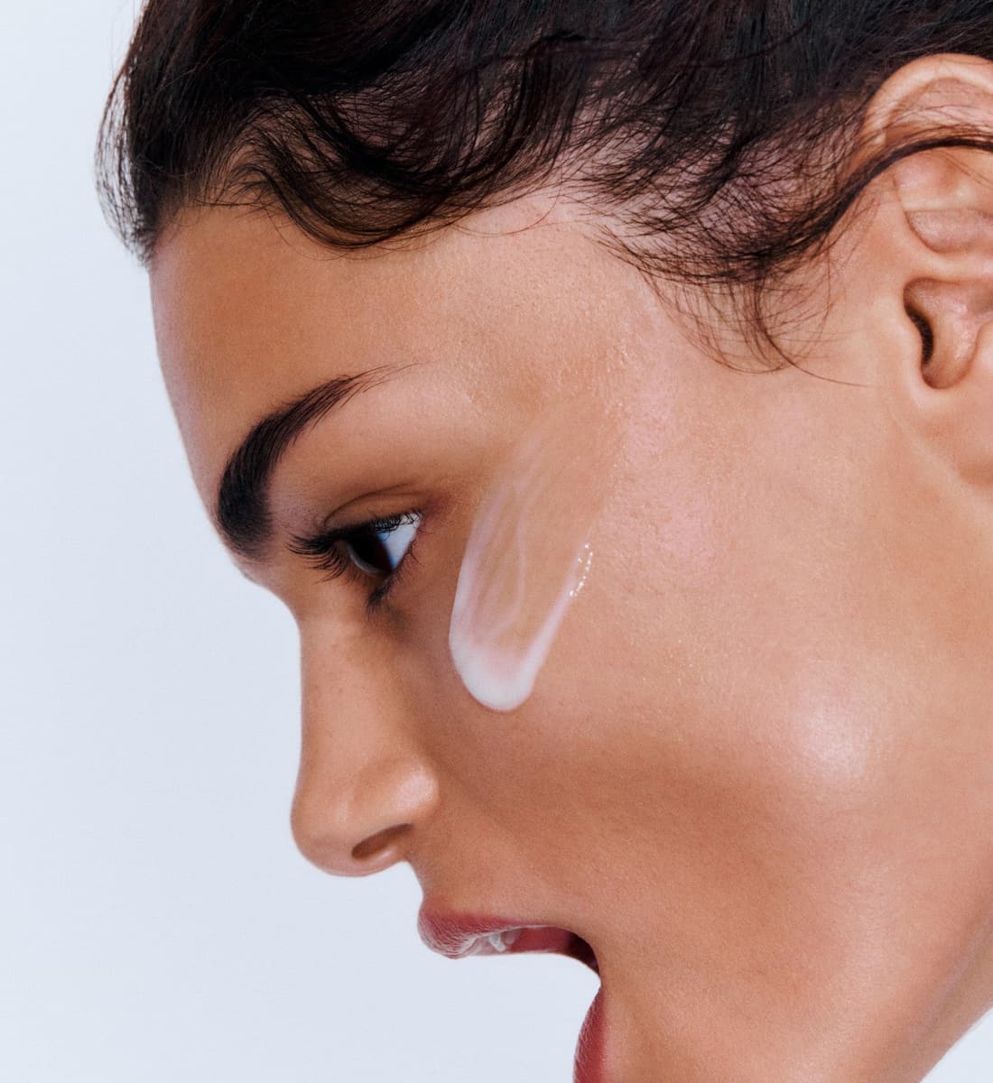 model with a swatch of peptide glazing fluid on her face